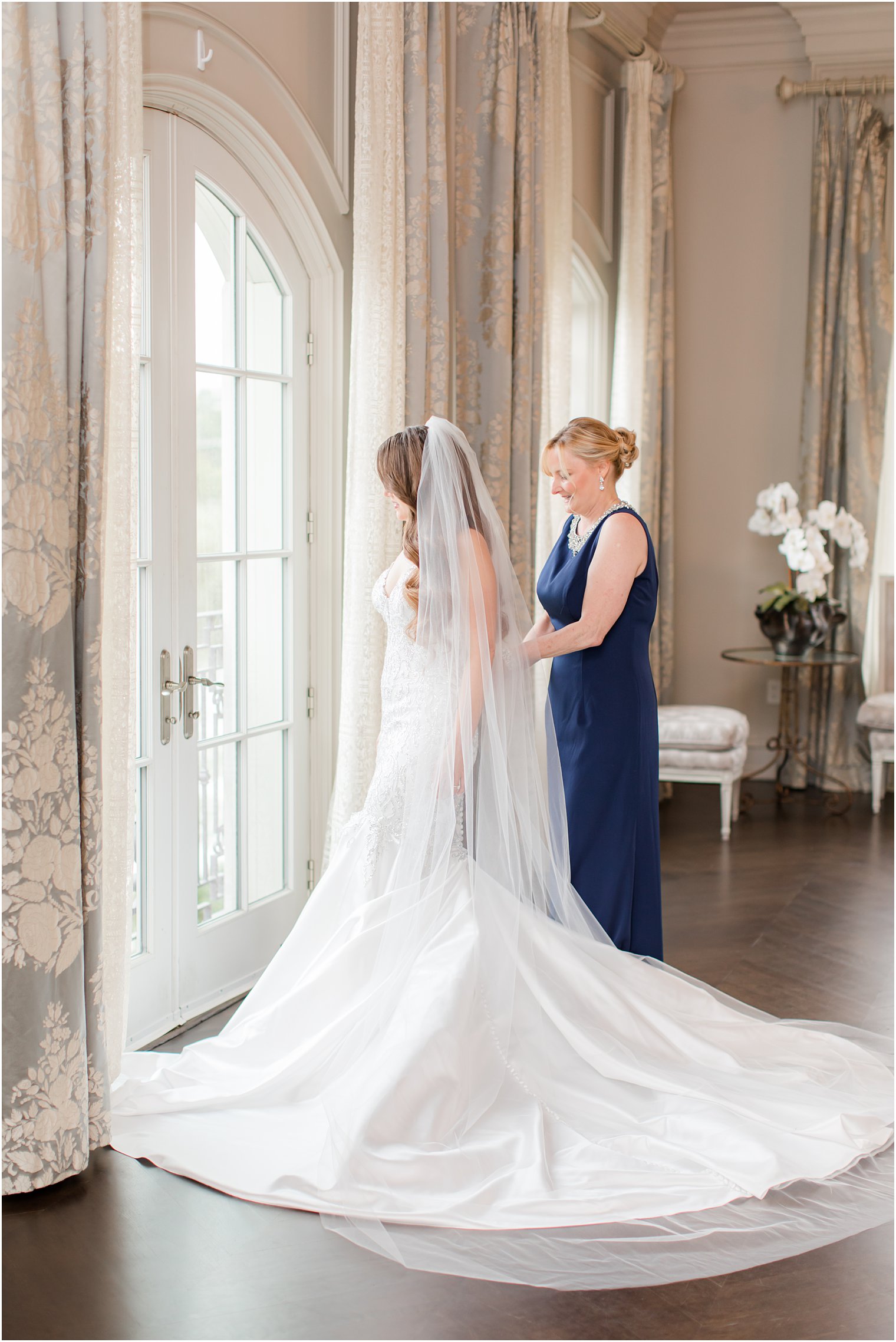 mom helps bride with wedding gown at Park Chateau Estate