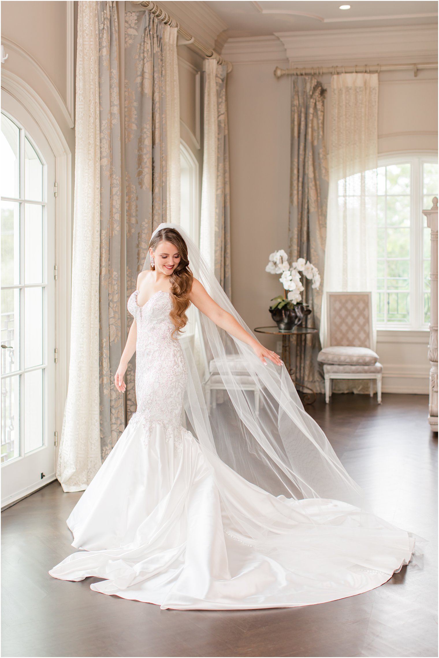 bride holds veil behind her during NJ wedding portraits at Park Chateau Estate