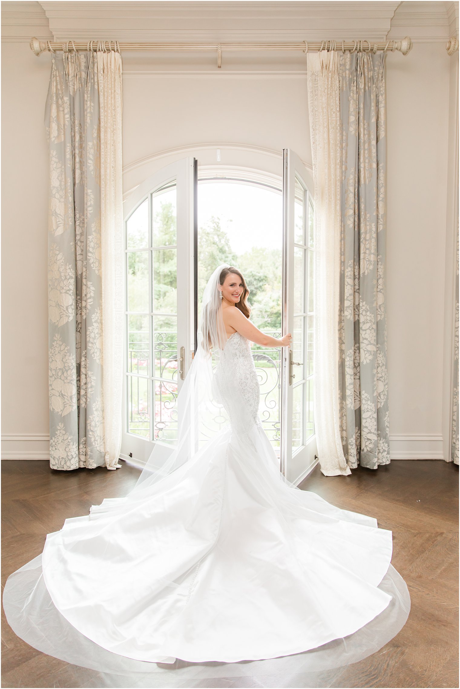 bride poses in window of bridal suite looking over shoulder at Park Chateau Estate