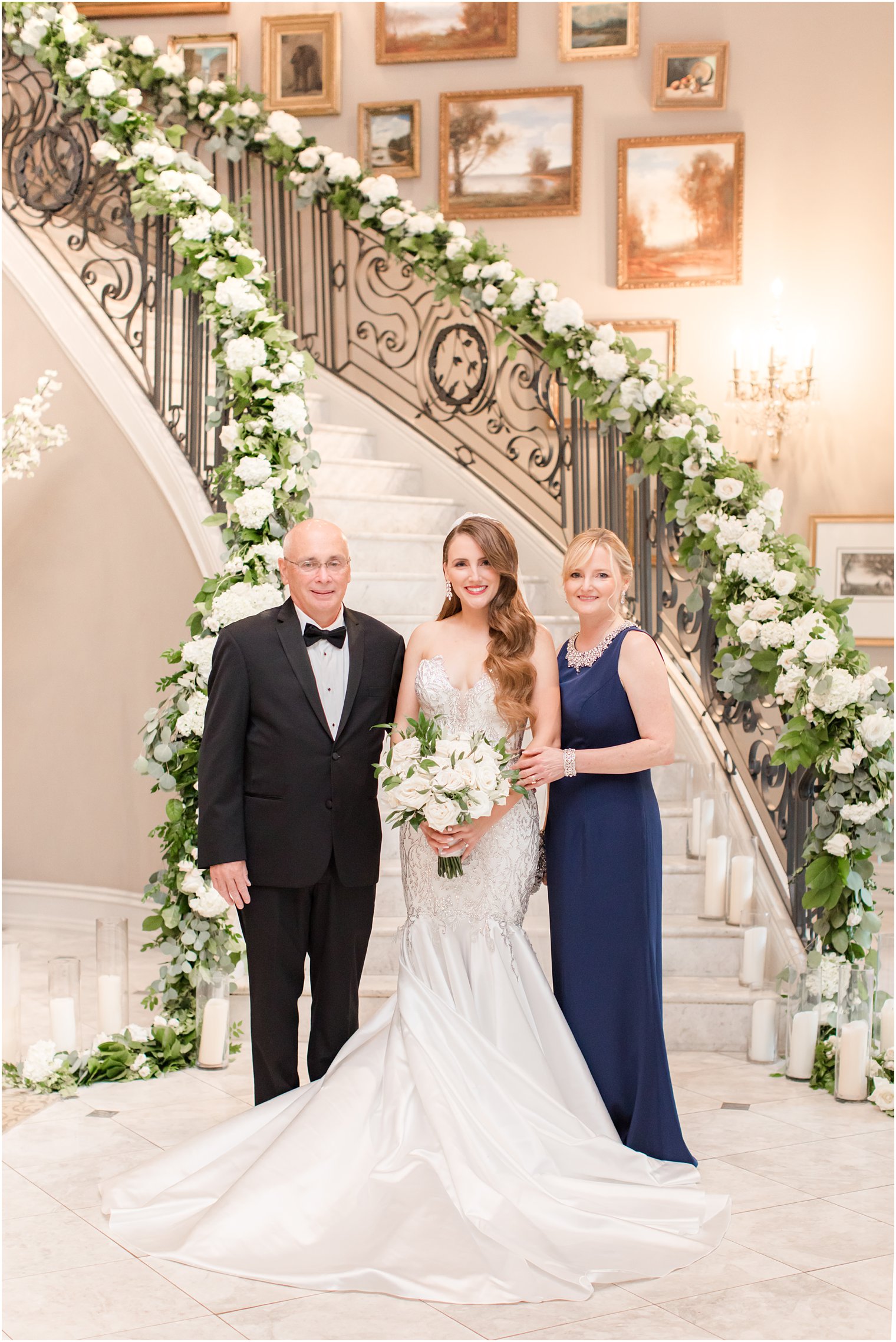 bride poses with parents by staircase in Park Chateau Estate