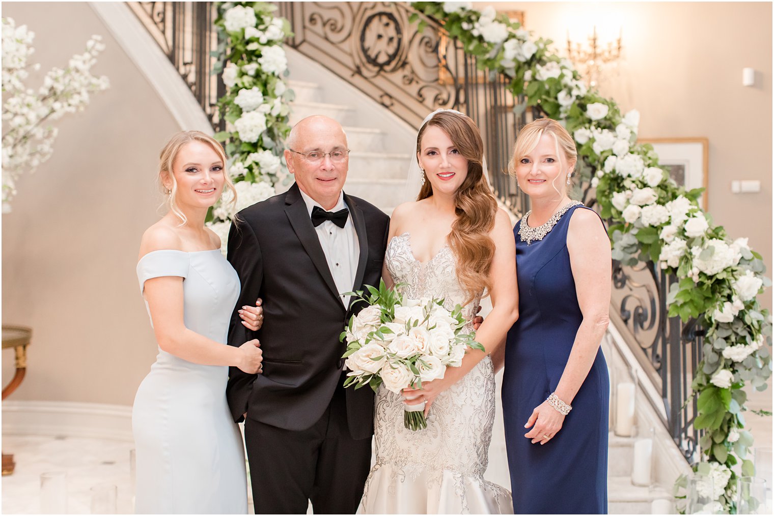 bride poses with parents and sister before NJ wedding day