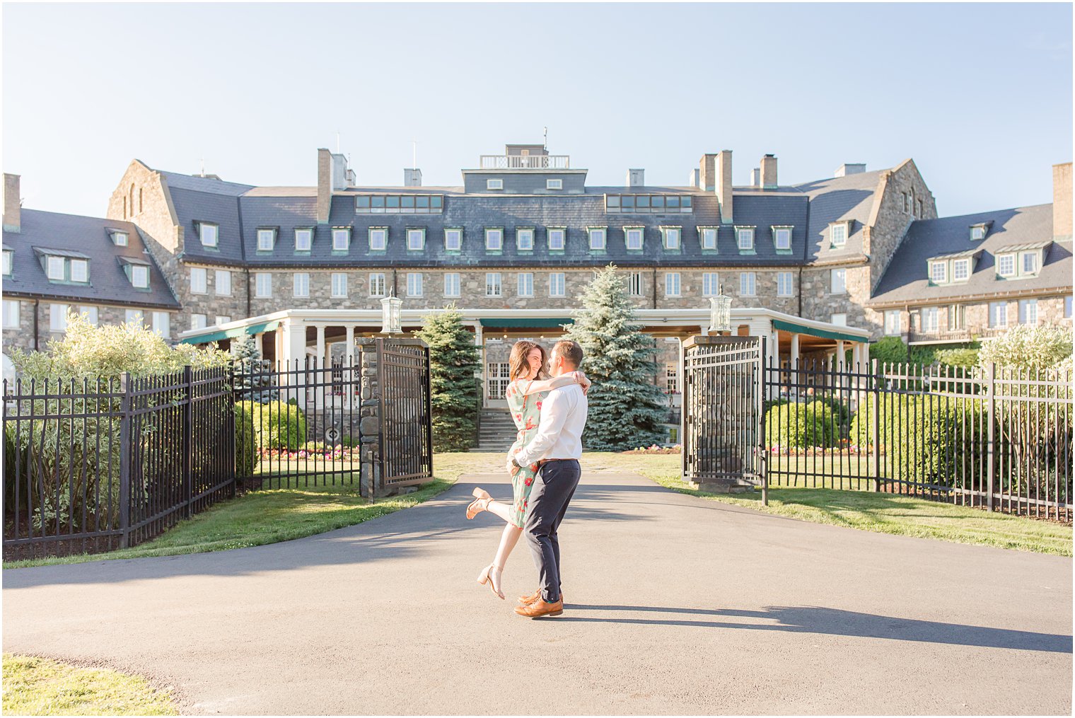 groom lifts bride outside the gates at Skytop Lodge in Poconos PA