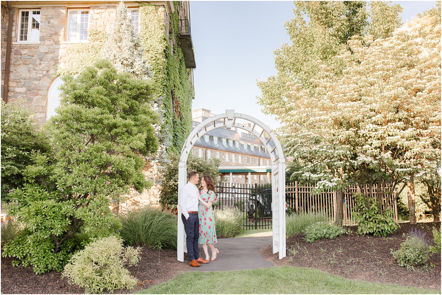 couple kisses by wooden archway at PA hotel 