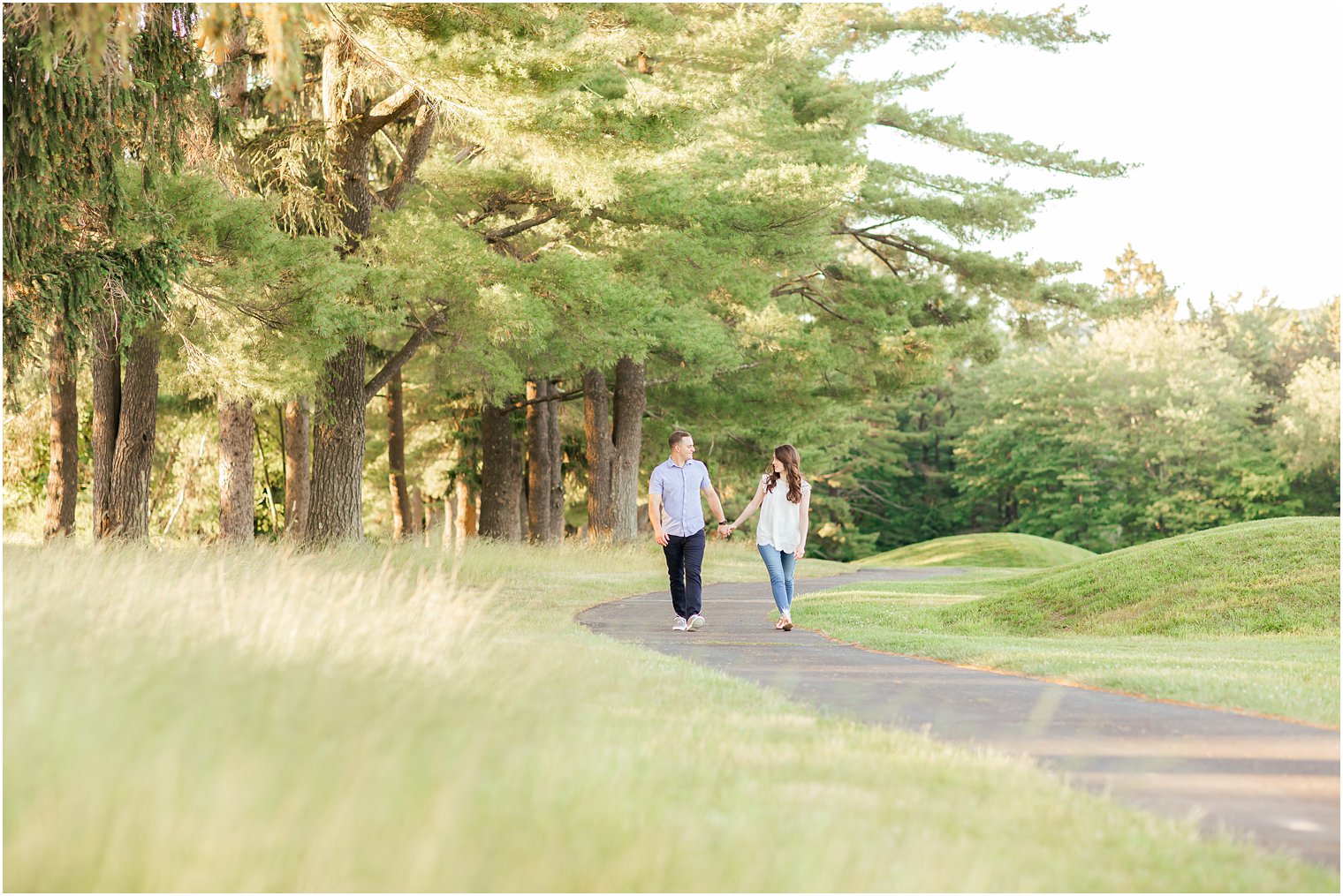 bride and groom hold hands walking through the Poconos PA