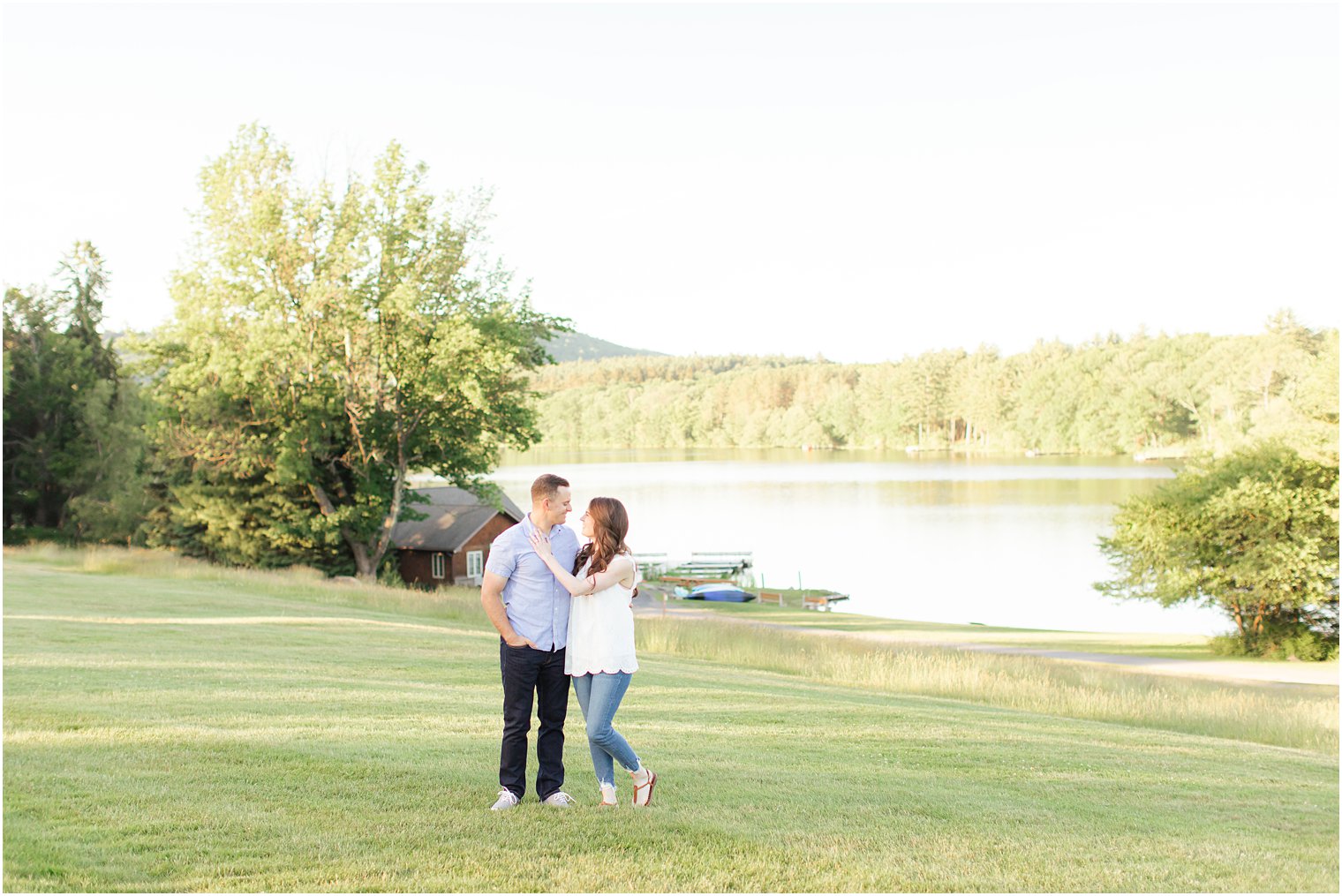 bride and groom pose by lake in the Poconos PA