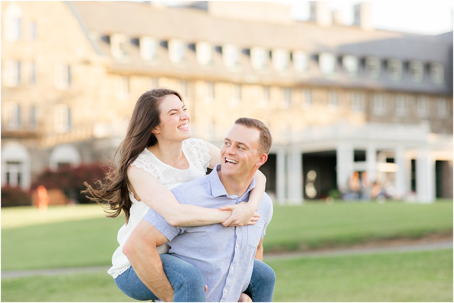 groom gives bride a piggy back ride outside the Skytop Lodge