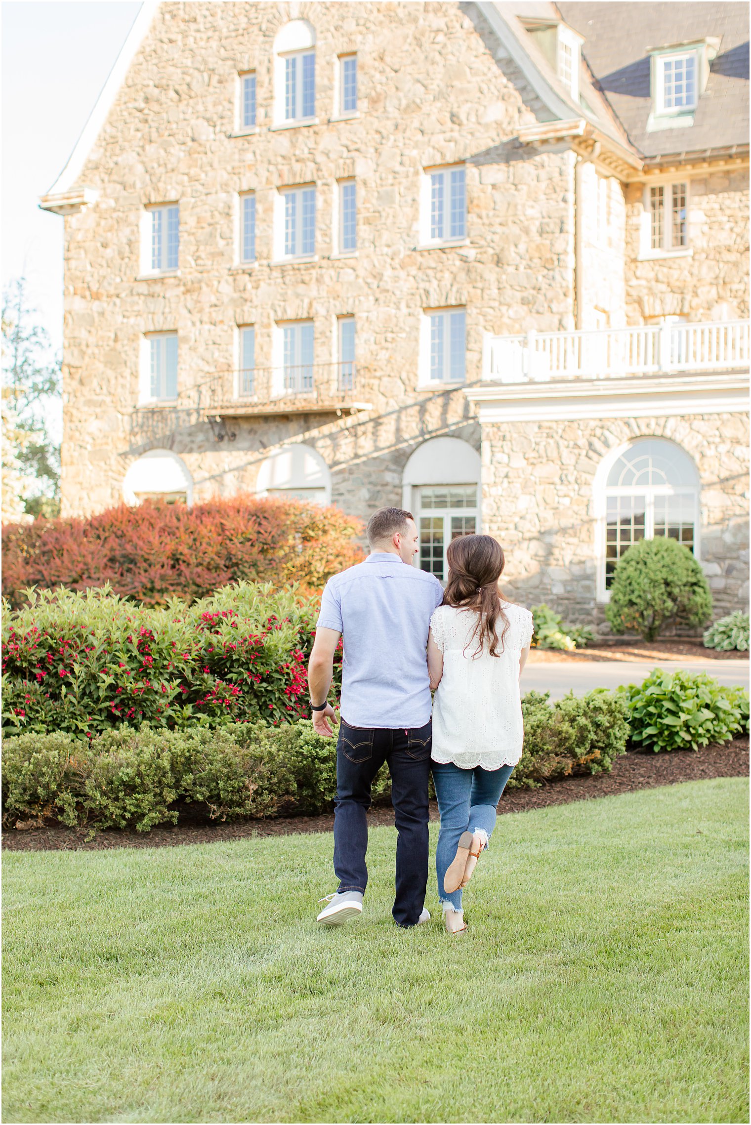 engaged couple runs on lawn during Skytop Lodge engagement photos 