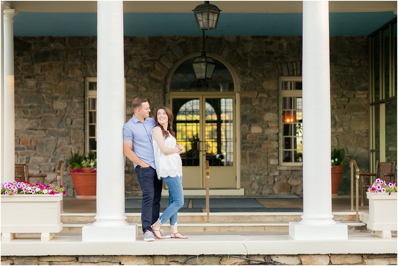 engaged couple hug by pillar along entrance at the Skytop Lodge