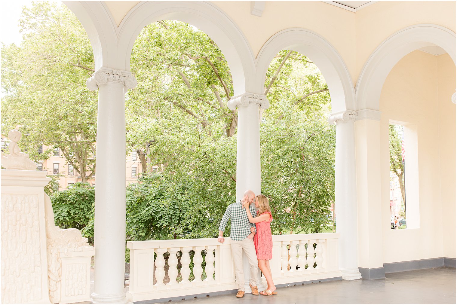 couple poses under archway in Hoboken NJ