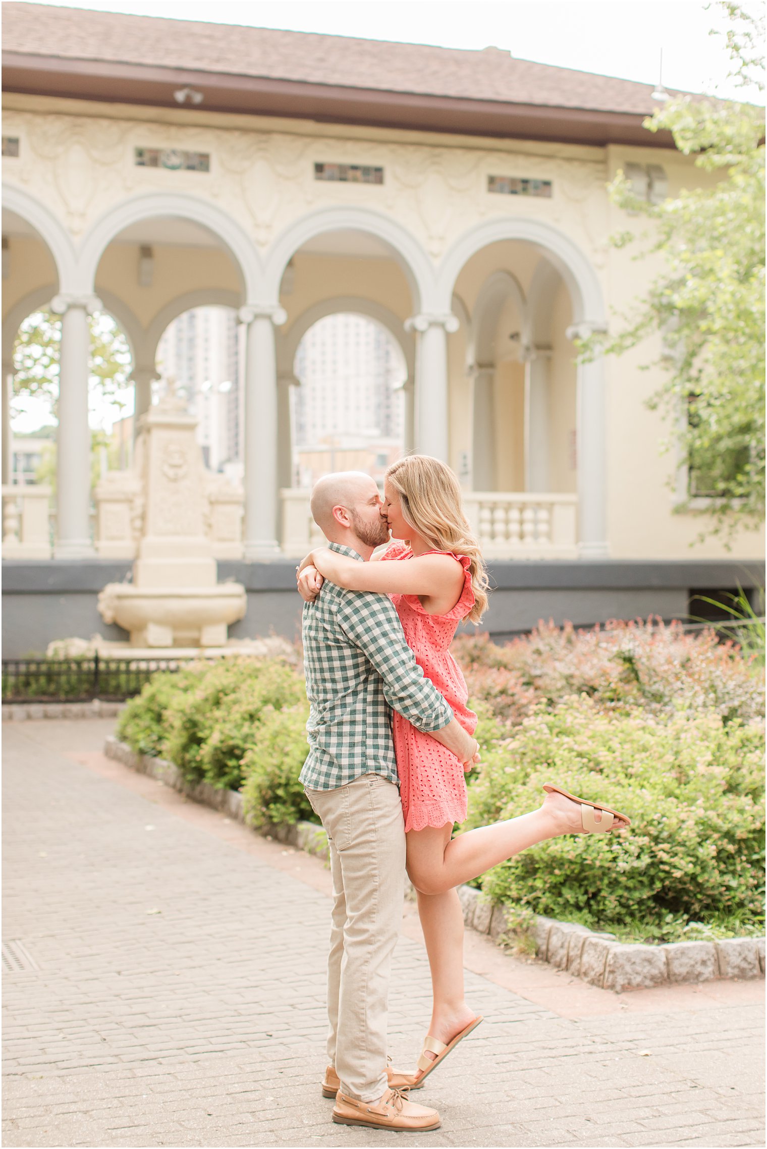 engaged couple kisses in gardens during summer Hoboken engagement session