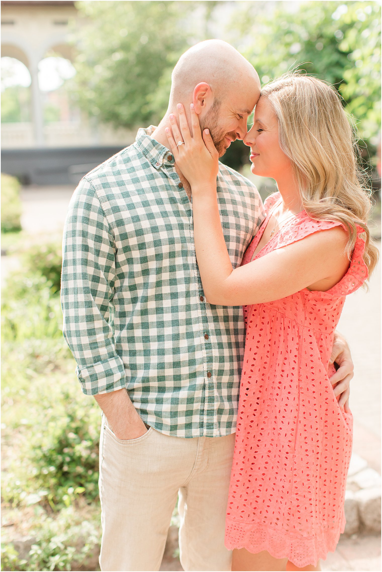 engaged couple stands touching noses in gardens of Hoboken NJ