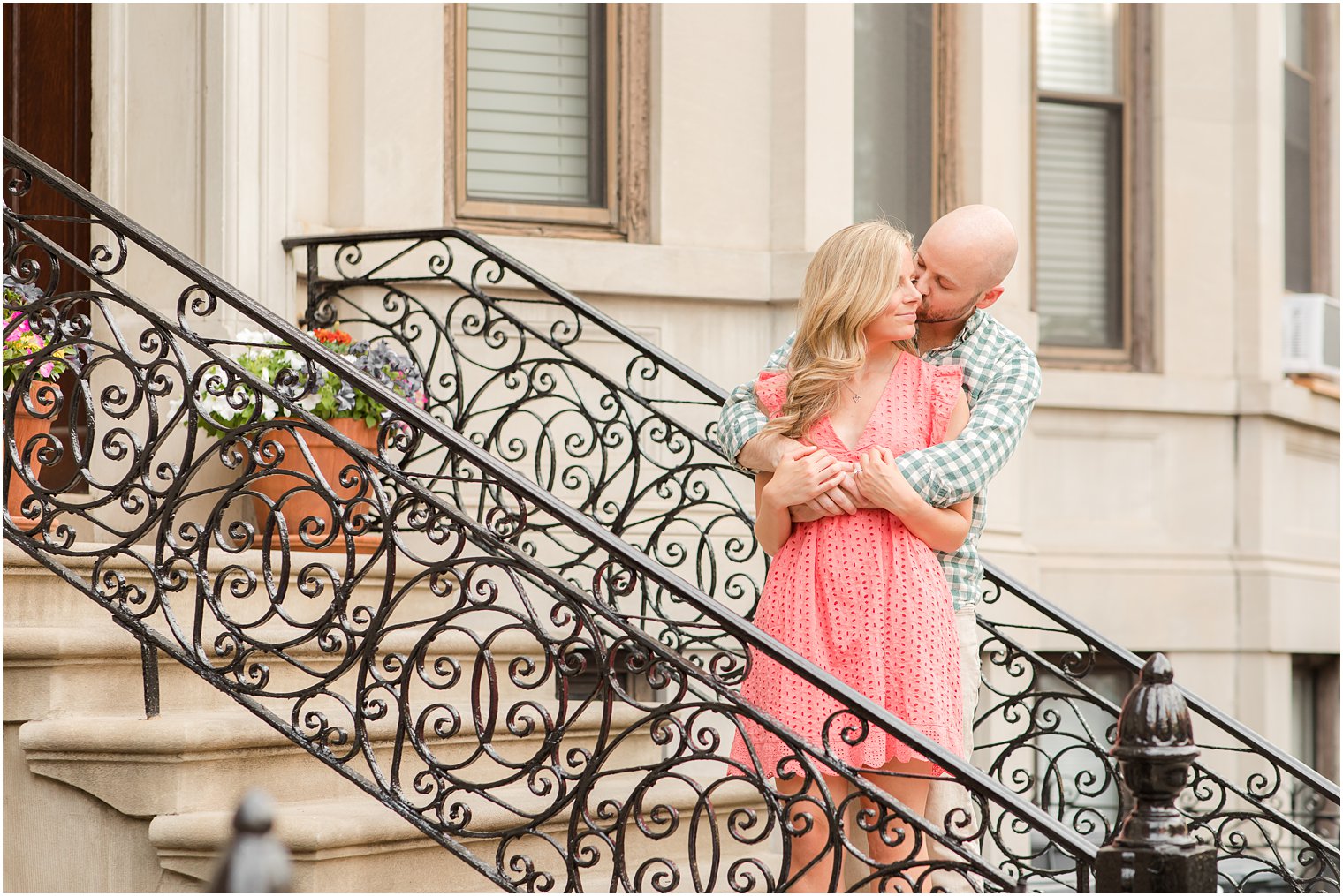 bride and groom pose on steps with wrought iron railing