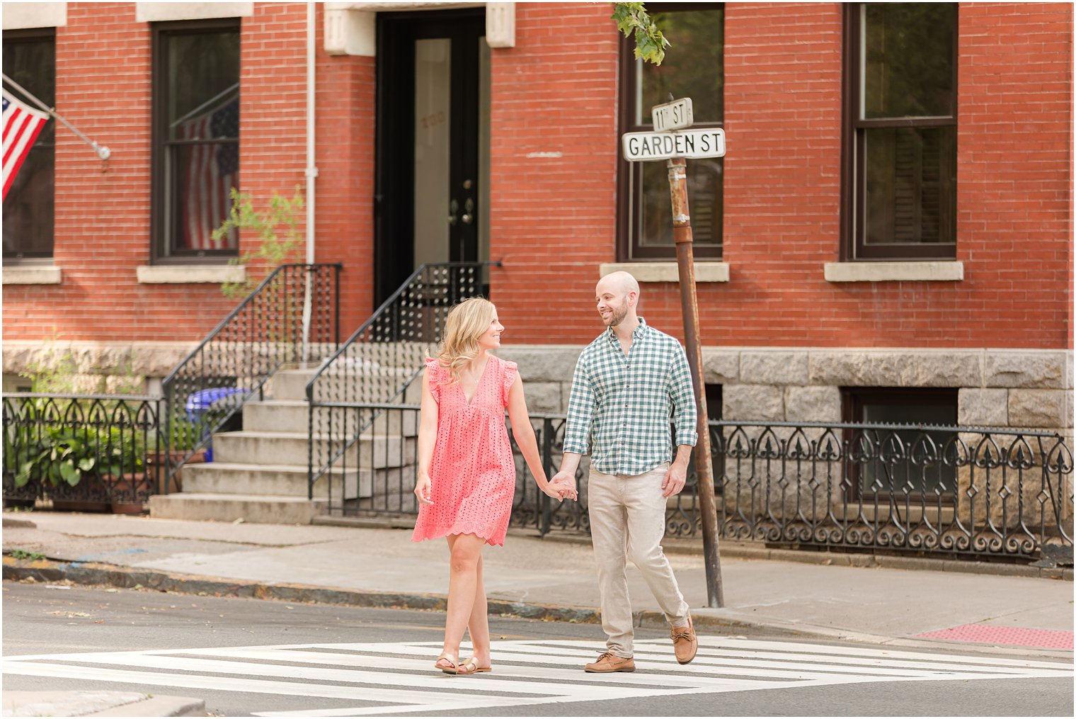 engaged couple holds hands walking through crosswalk in Hoboken NJ