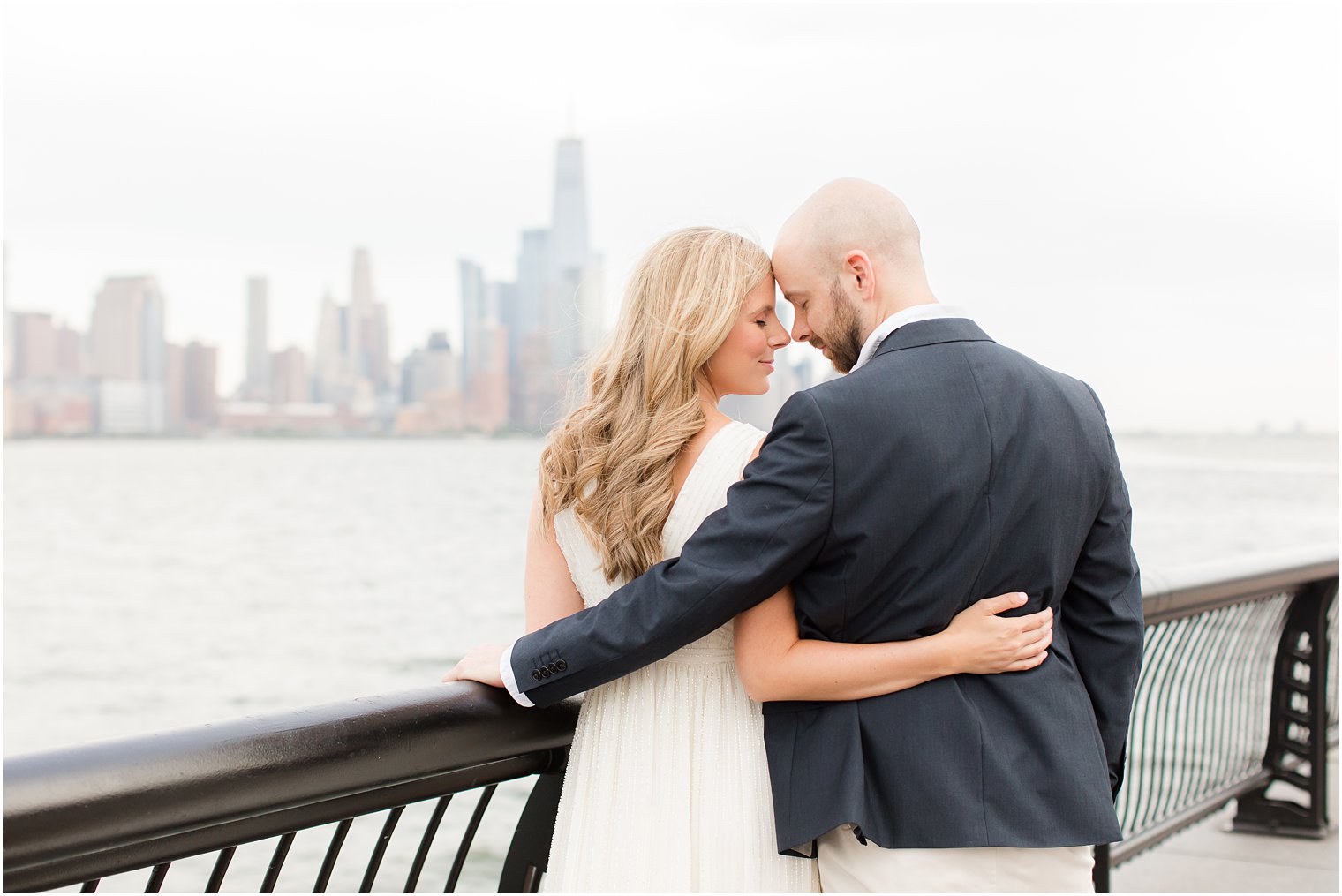 engaged couple stands together touching noses