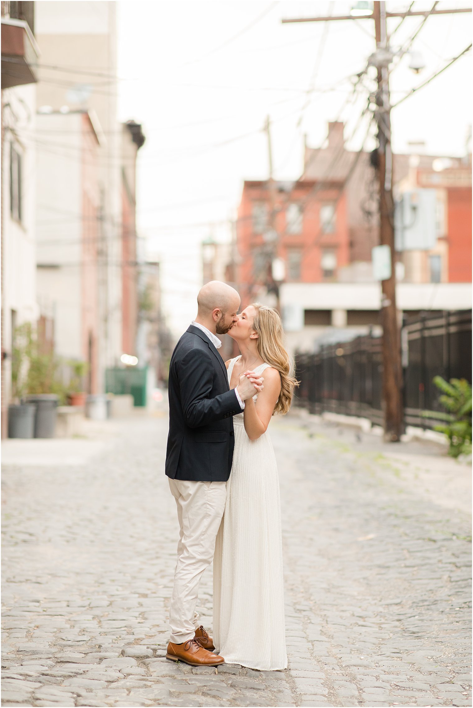 engaged couple kisses on downtown street in Hoboken