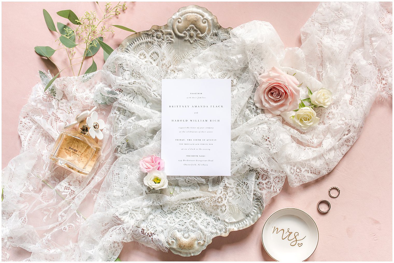 wedding invitation and perfume bottle on veil before NJ wedding