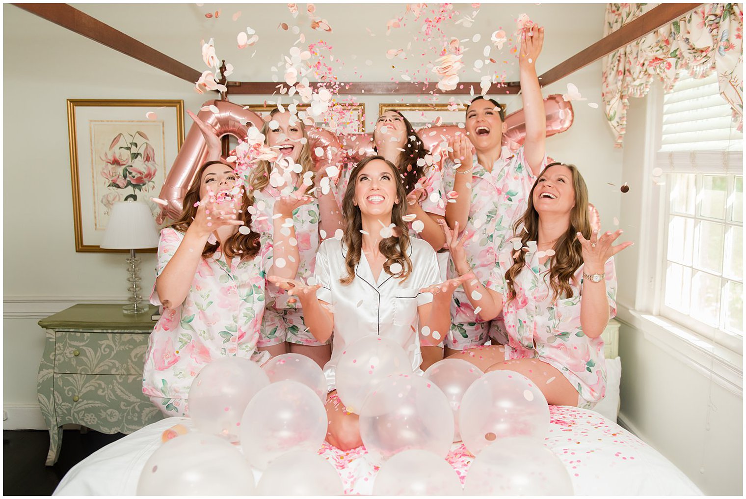 bride and bridesmaids throw confetti during wedding prep