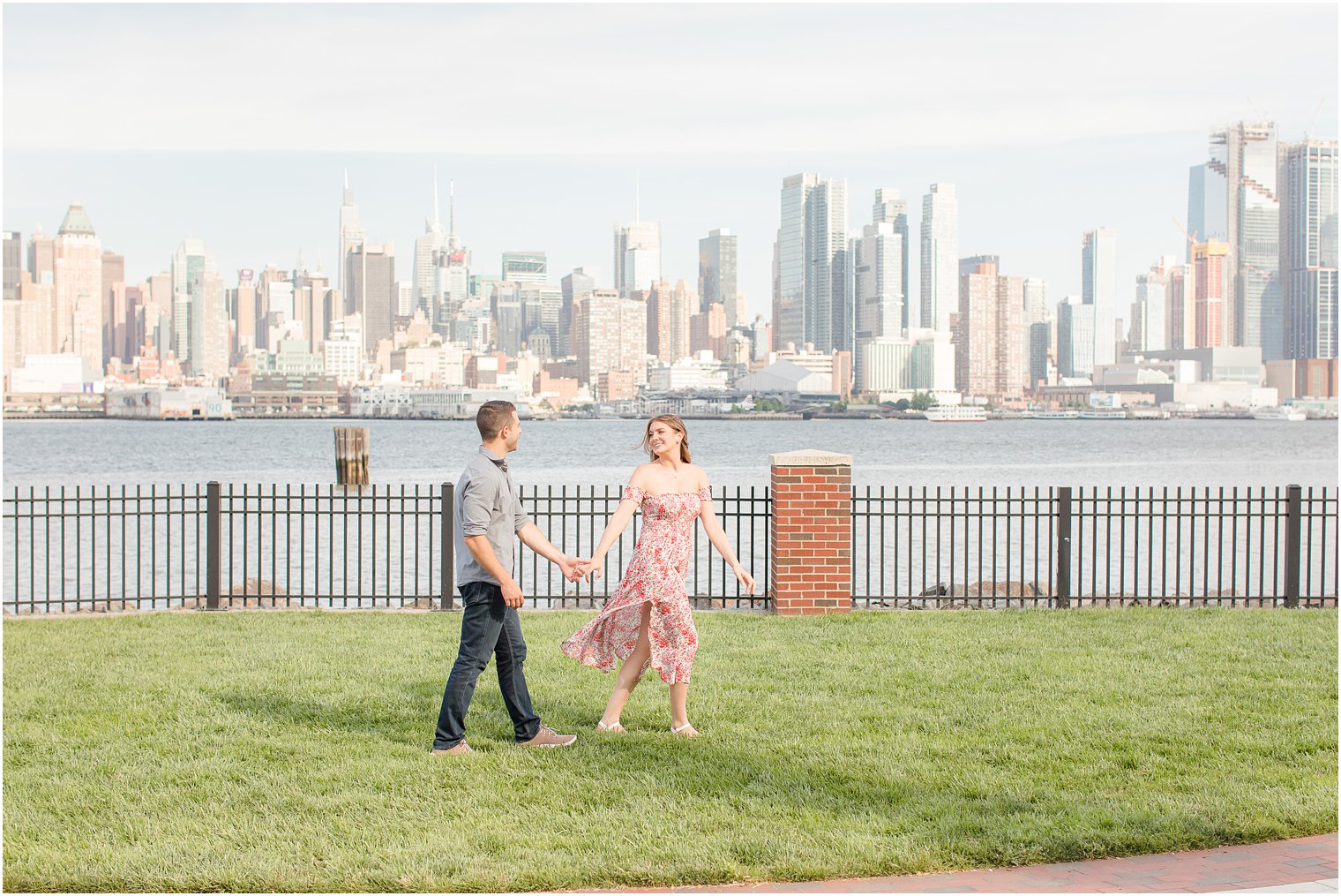 engaged couple holds hands walking through park in Weehawken NJ