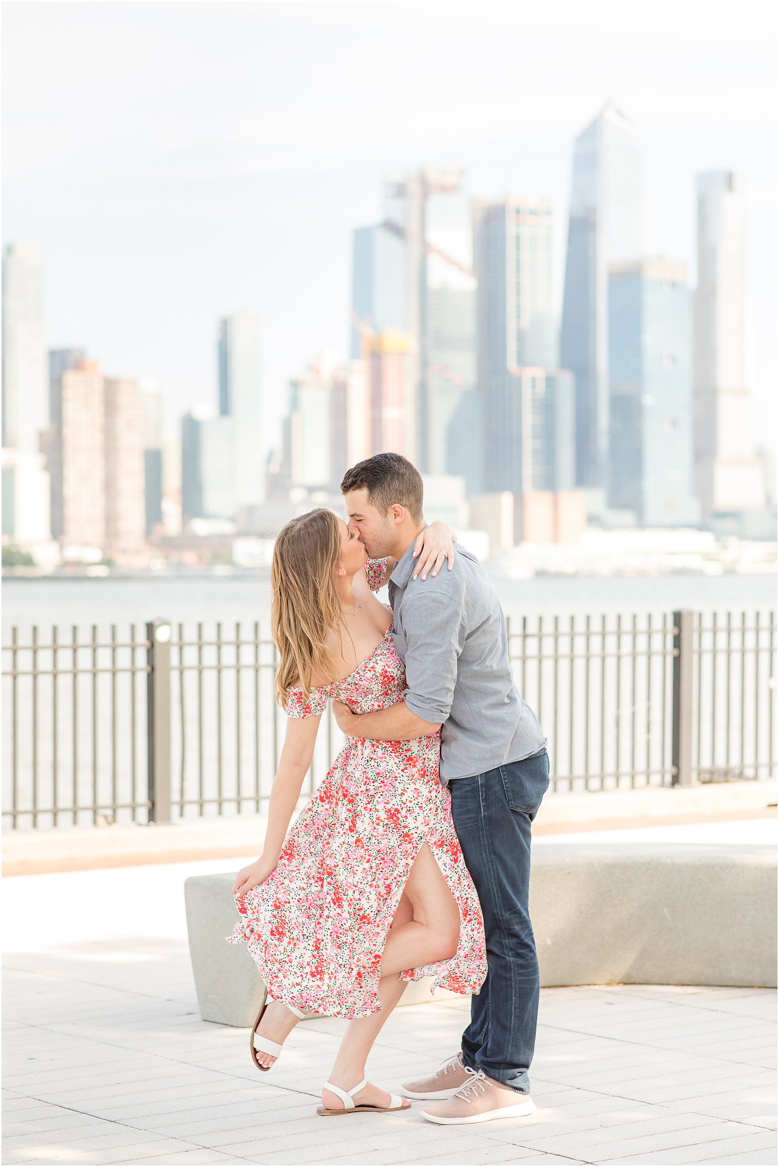 bride and groom kiss while bride holds dress