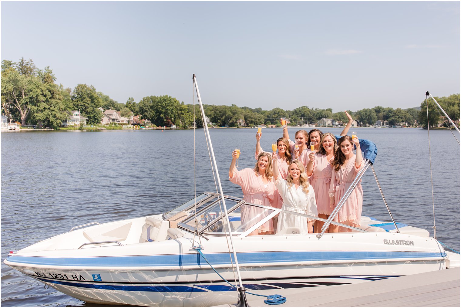bride and bridesmaids toast with mimosas on boat at Franklin Lakes NJ
