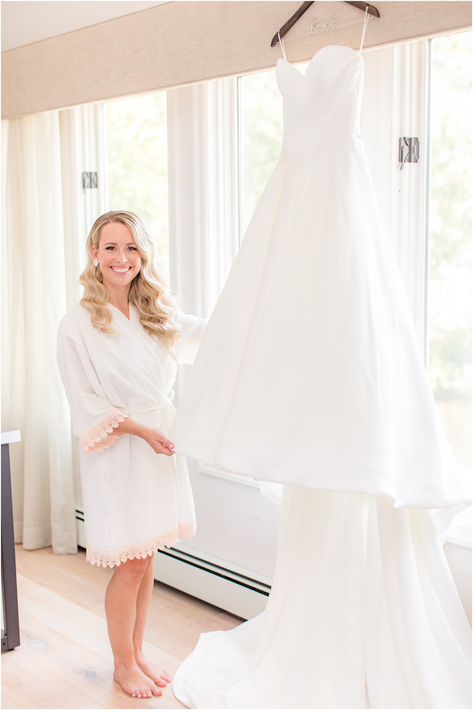 bride looks at classic wedding gown before Indian Trail Club wedding 