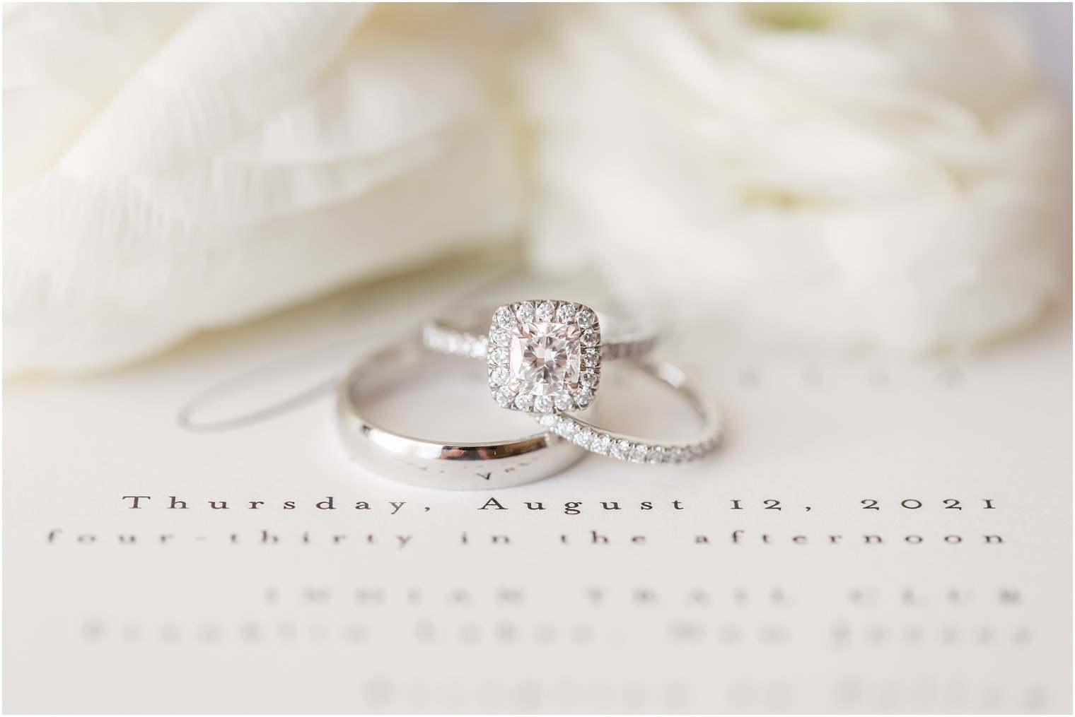 wedding rings sit on classic wedding invitation 