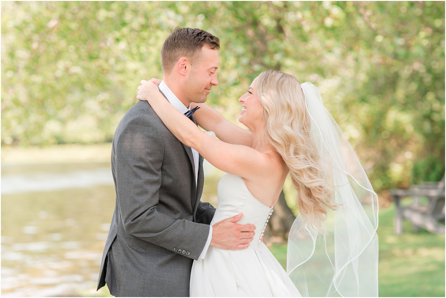 newlyweds hug with bride's veil floating at Indian Trail Club