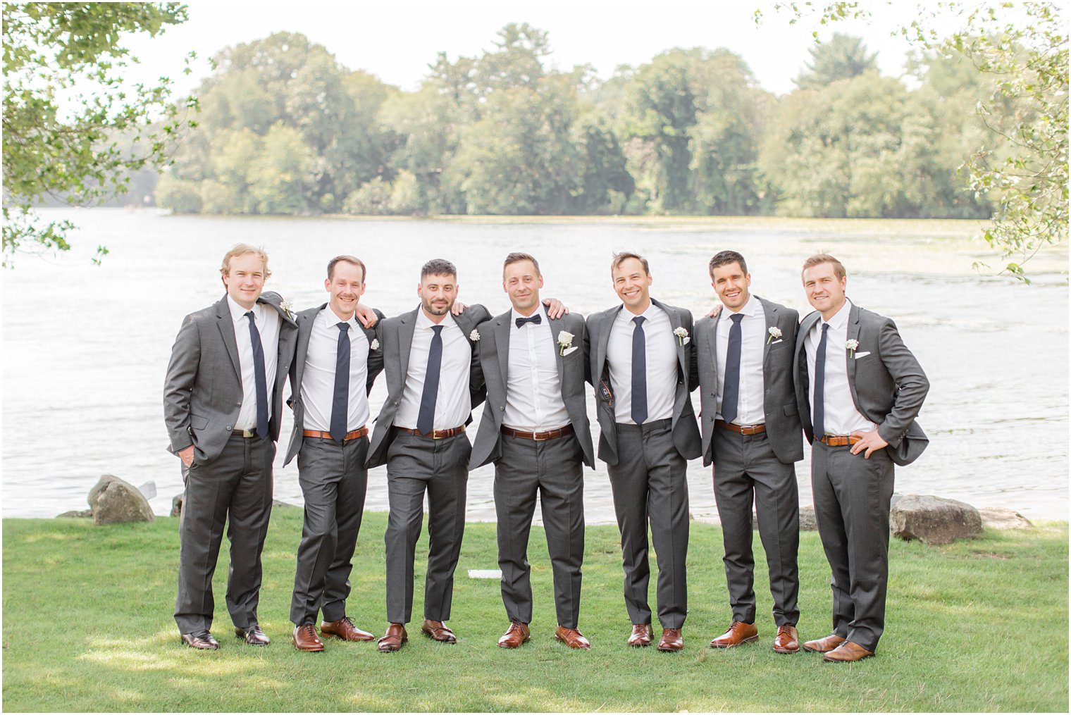 groom hugs groomsmen in grey suits for NJ wedding day