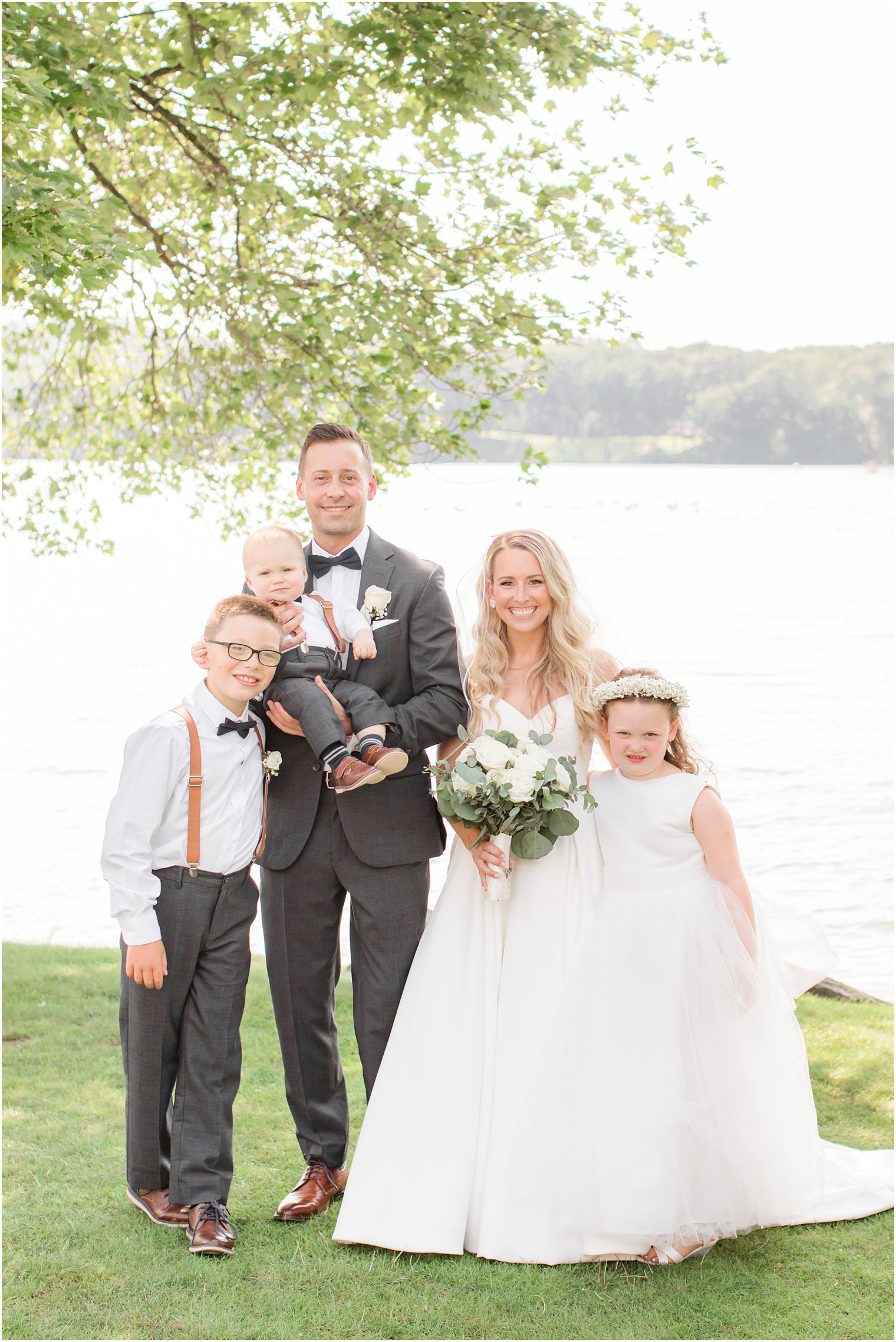 bride and groom pose with ring bearers and flower girl