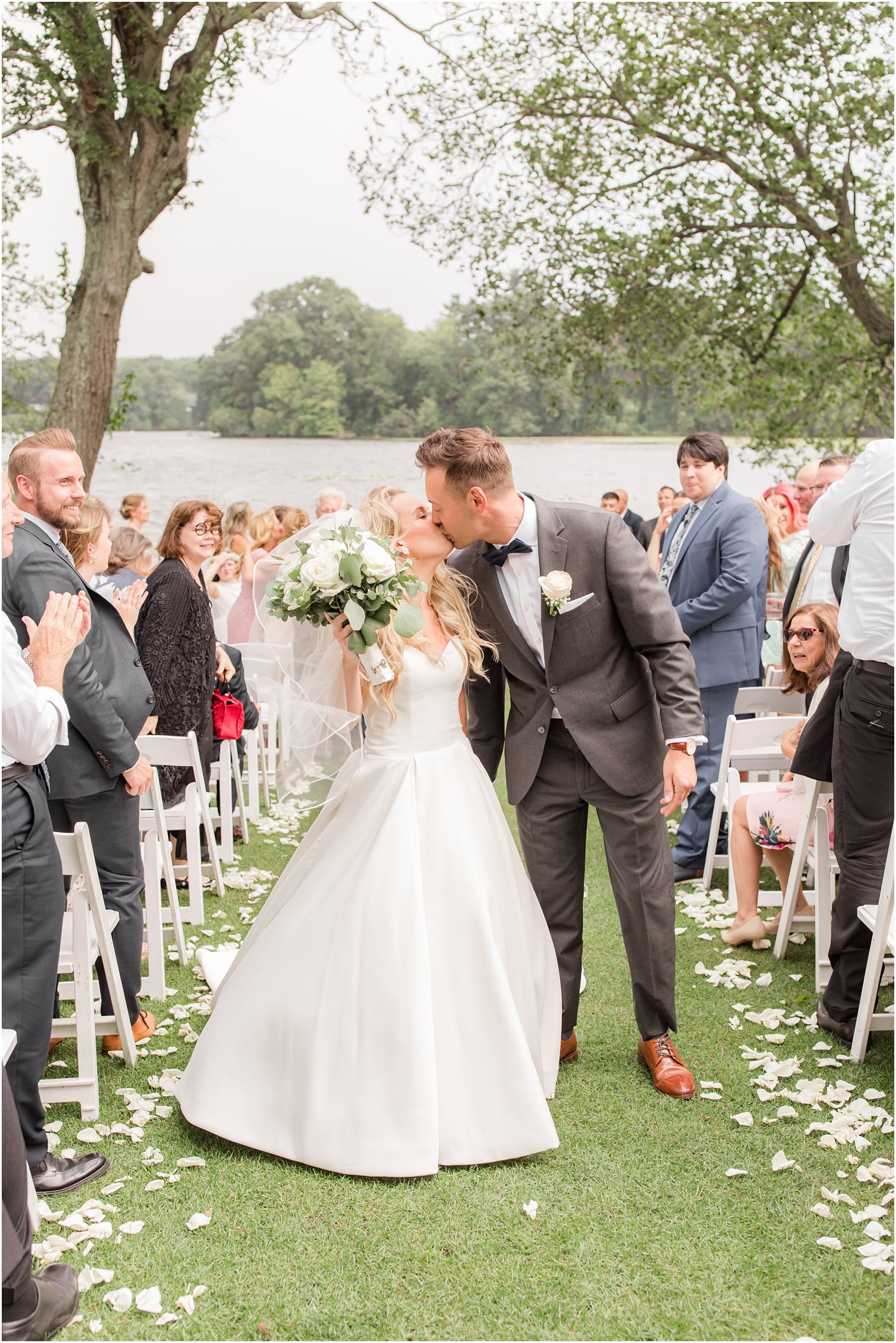 bride and groom kiss in aisle during outdoor wedding ceremony in Franklin Lakes