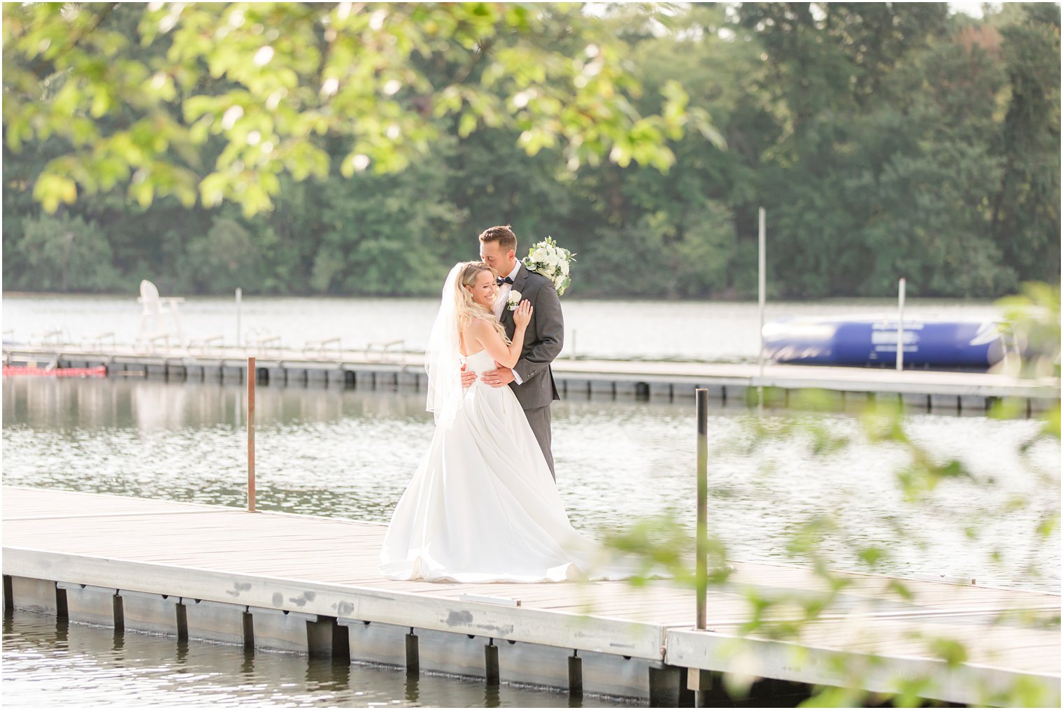 bride and groom hug on dock at Indian Trail Club