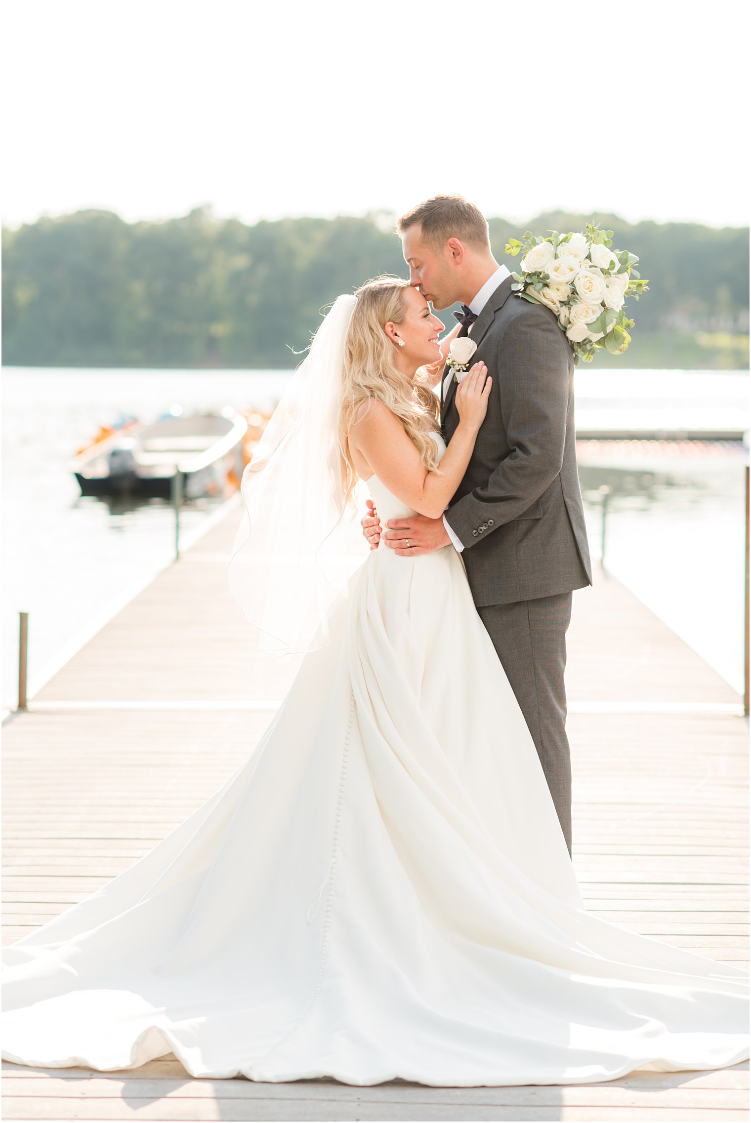 groom kisses bride's forehead during NJ wedding photos at Indian Trail Club