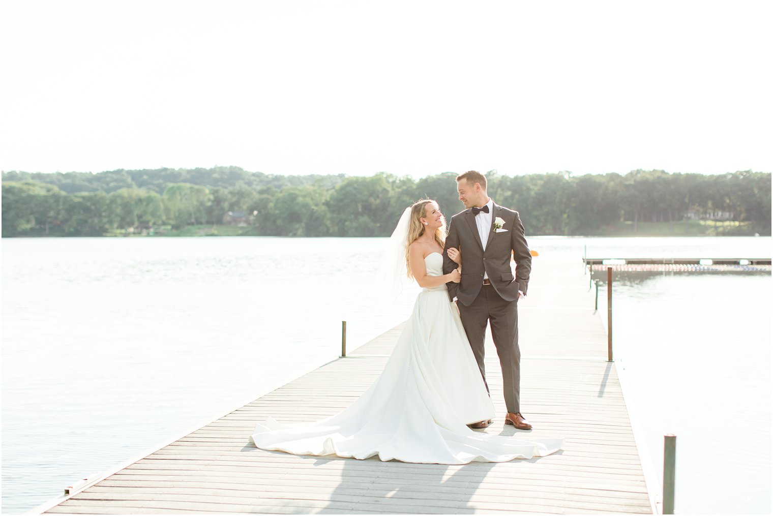 bride holds groom's arm on dock at Indian Trail Club