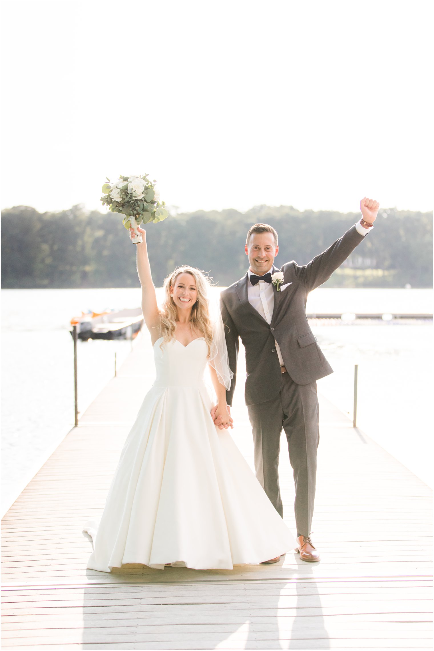 bride and groom cheer on dock at Indian Trail Club