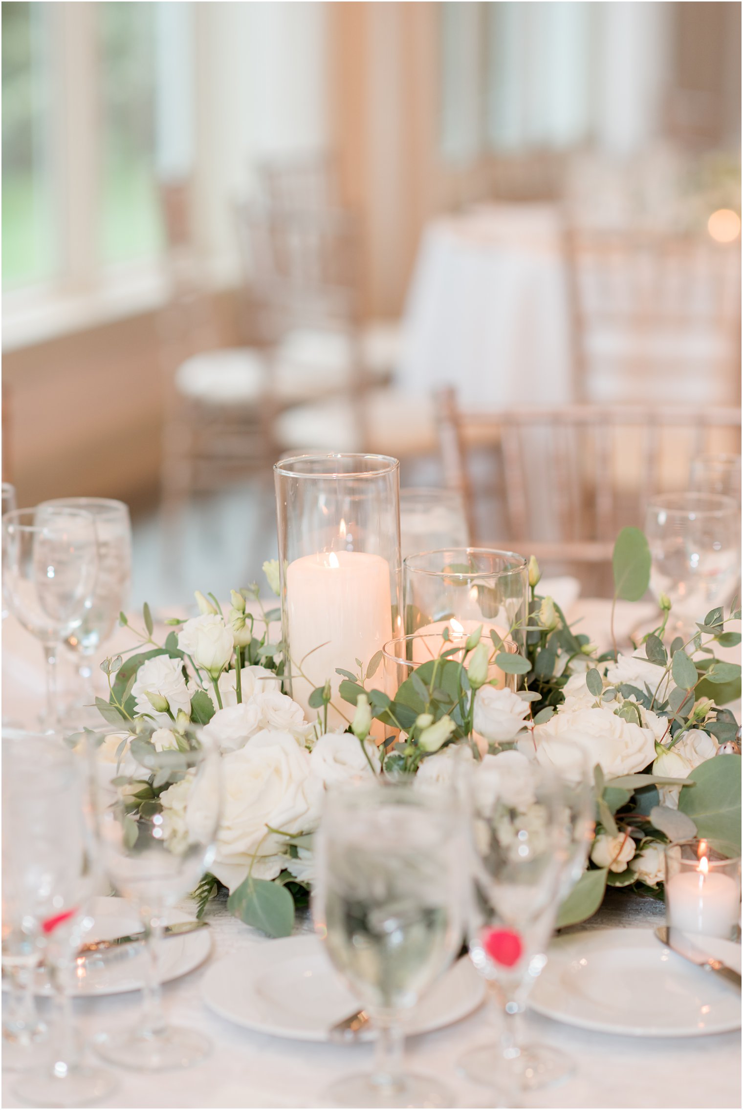 centerpieces with tall pillar candles and ivory flowers 