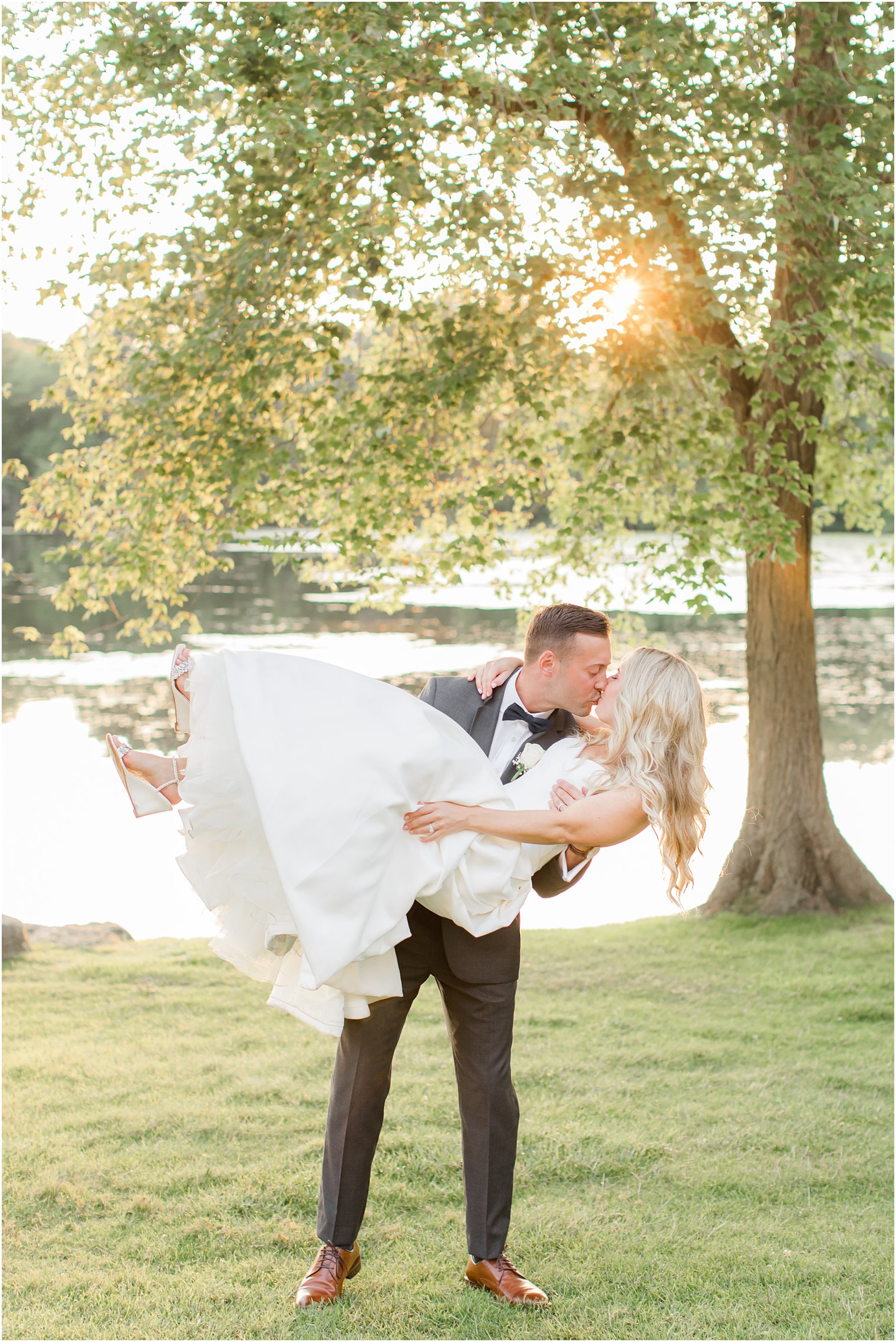 groom lifts bride during NJ wedding photos 