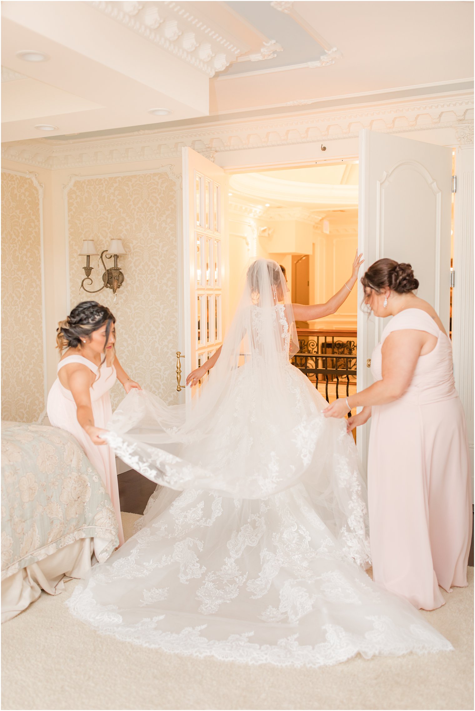 bridesmaids help bride with veil before NJ wedding day
