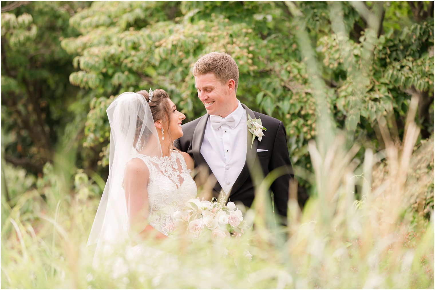 bride and groom laugh together in field at Ashford Estate