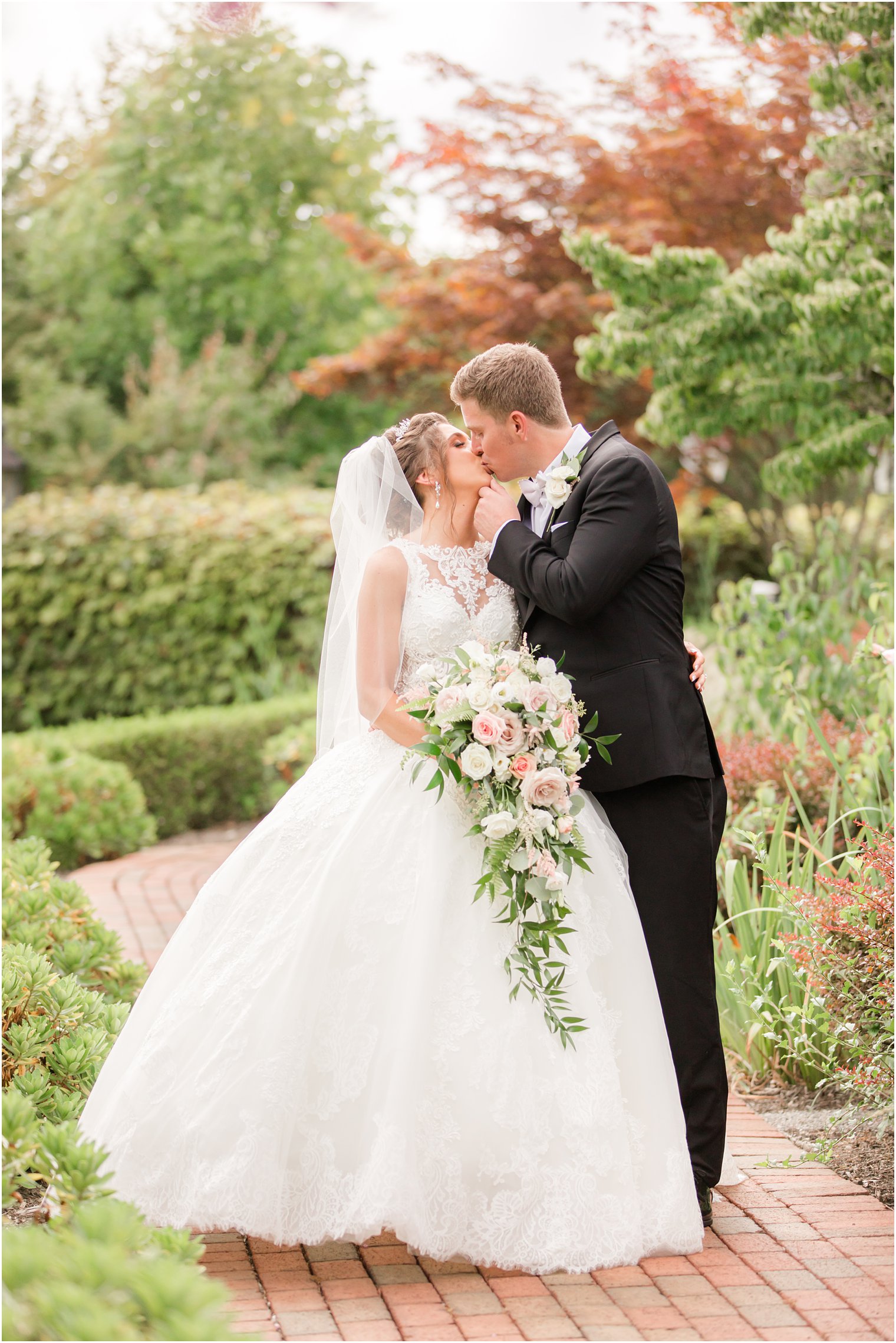 bride and groom kiss in gardens at Ashford Estate