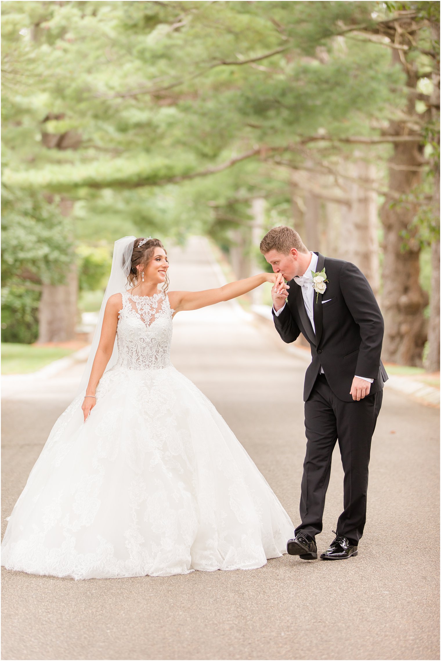 groom kisses bride's hand during NJ wedding photos 