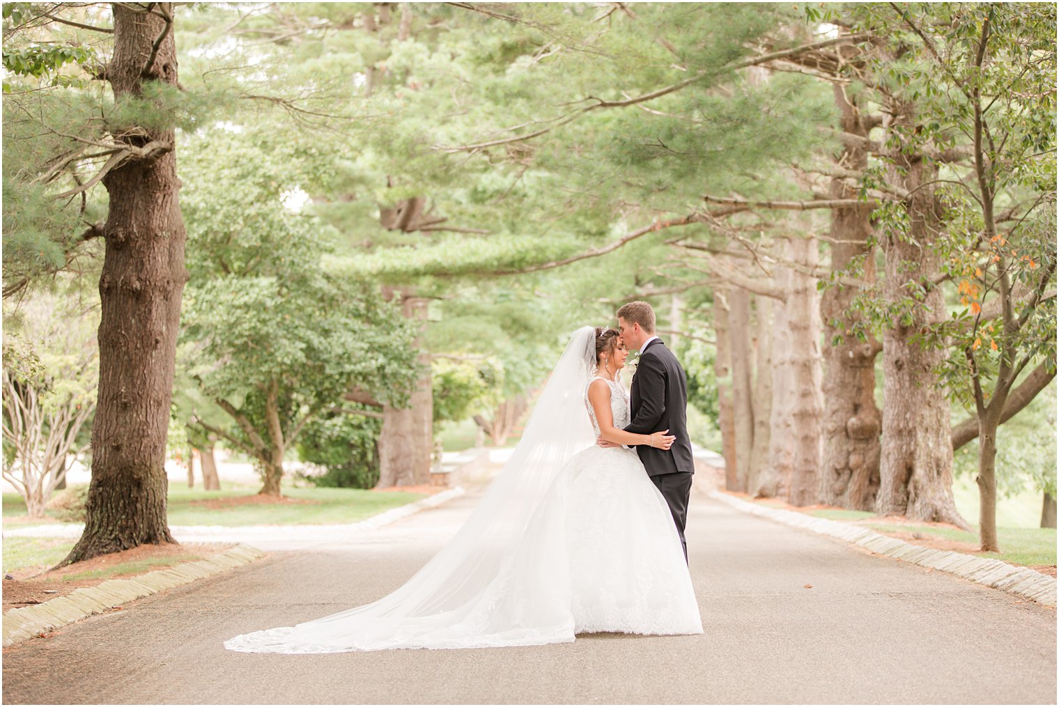 groom kisses bride's forehead on driveway of Ashford Estate