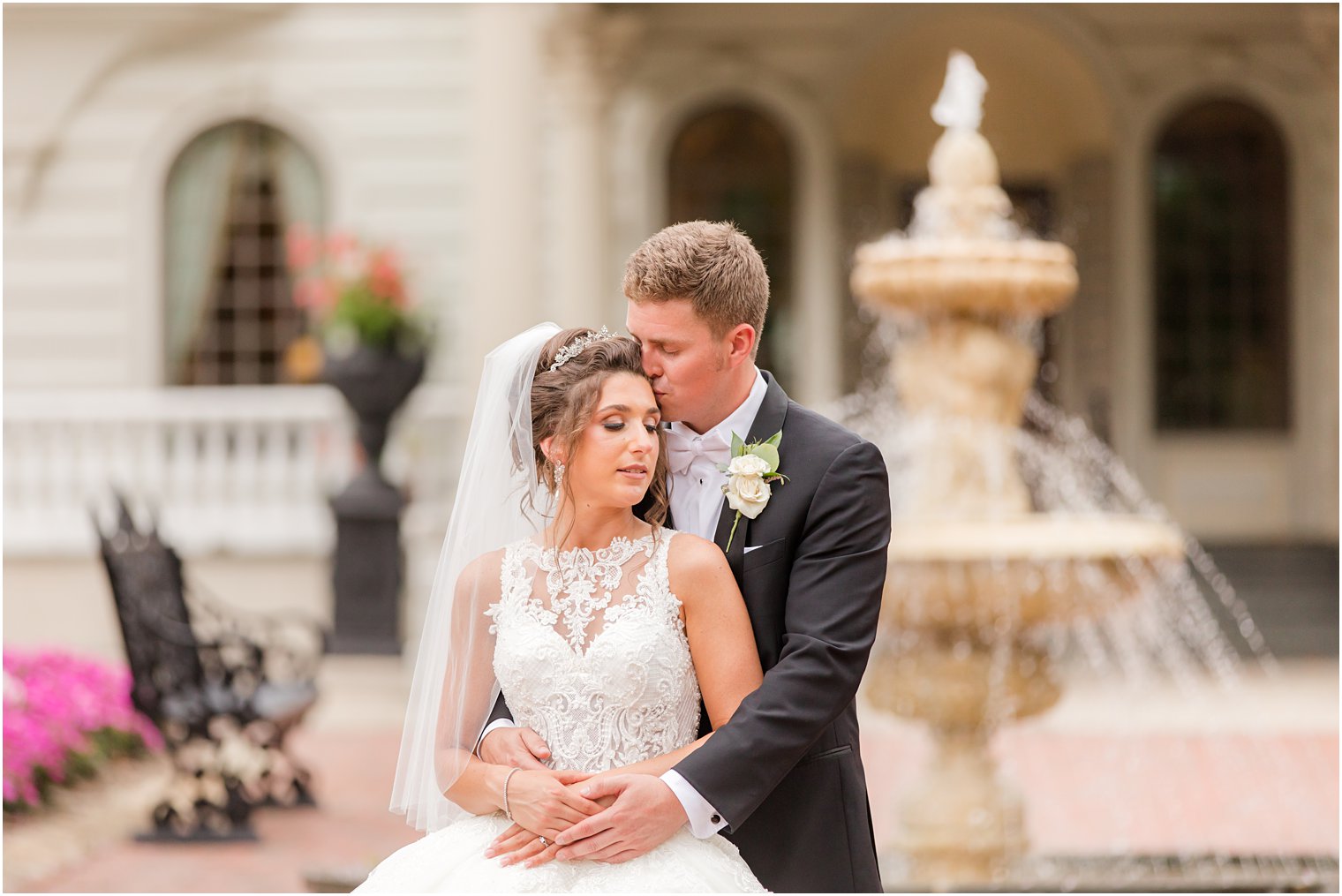groom hugs bride and kisses her forehead during wedding photos outside Ashford Estate