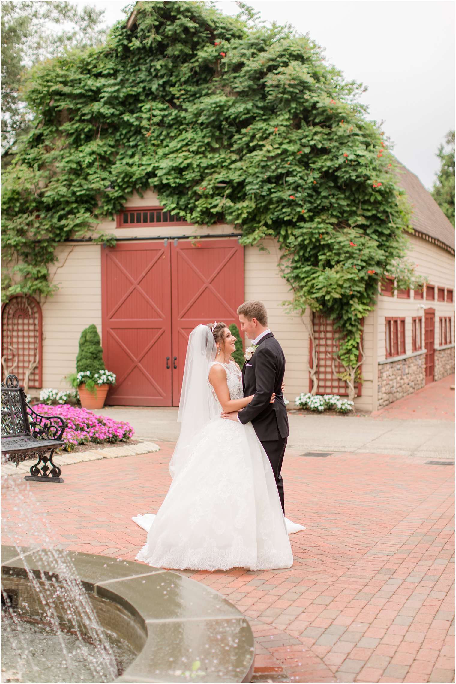 bride and groom hug outside barn at Ashford Estate