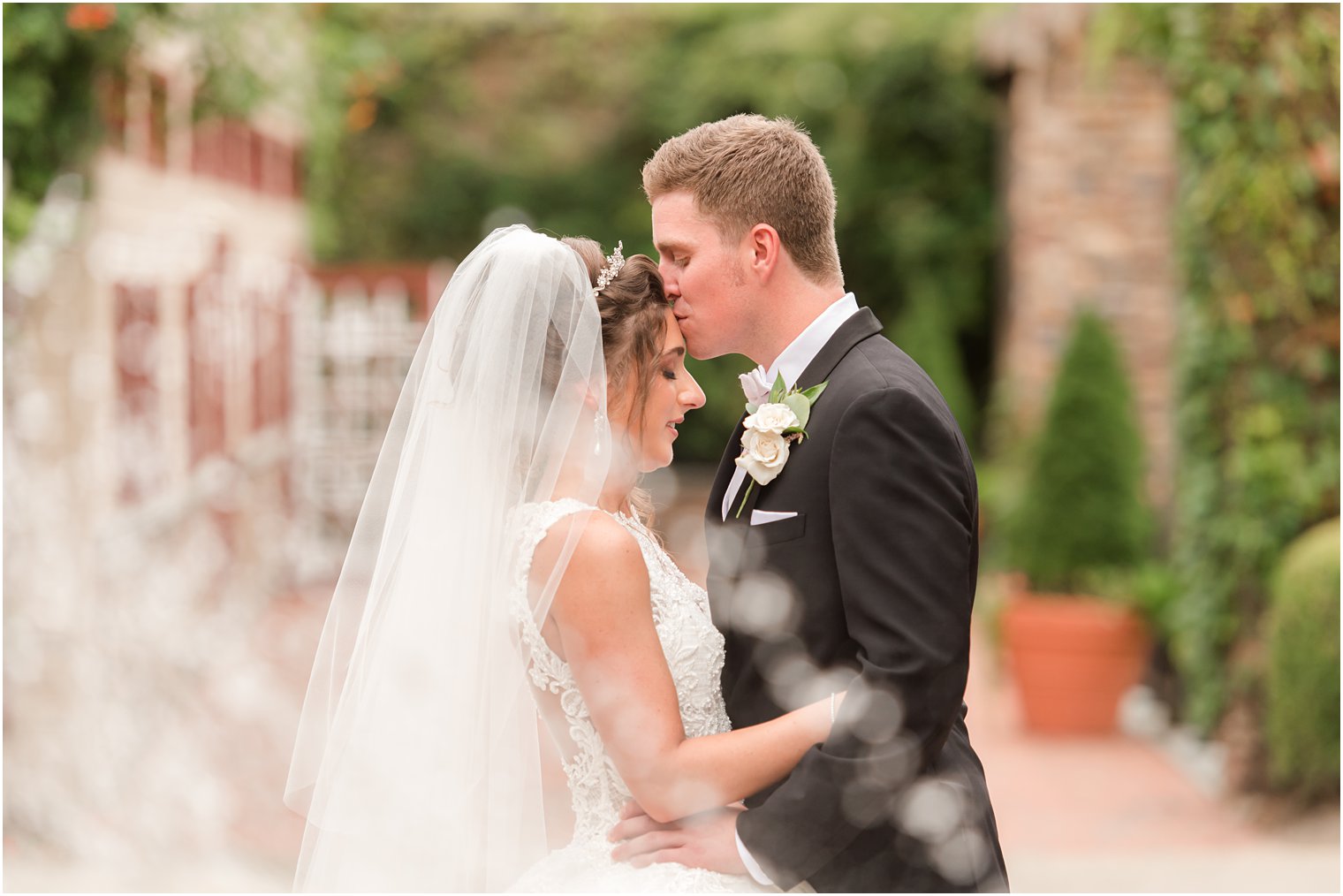 groom kisses bride's forehead during NJ wedding photos 