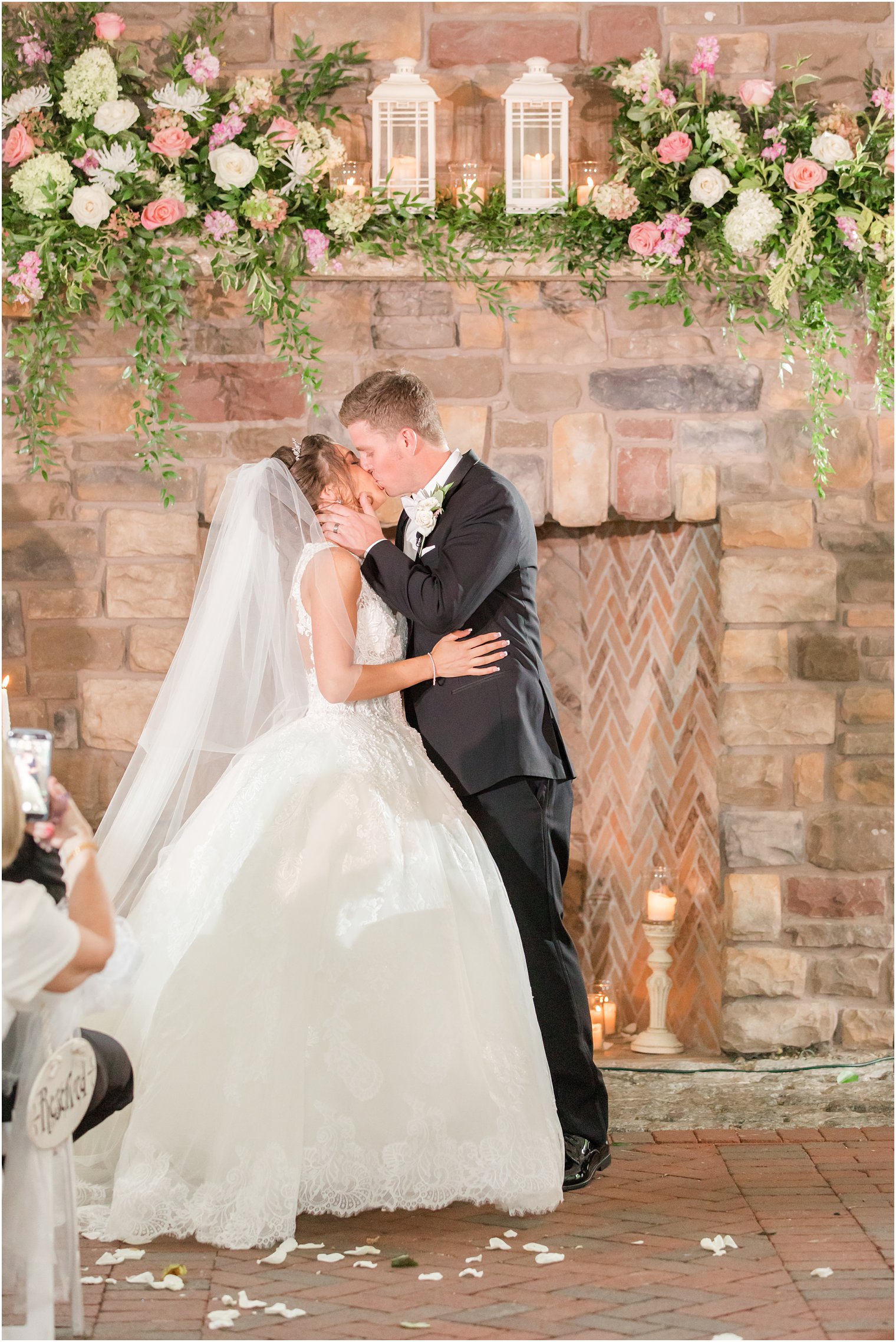 newlyweds kiss during NJ wedding ceremony in front of brick chimney 