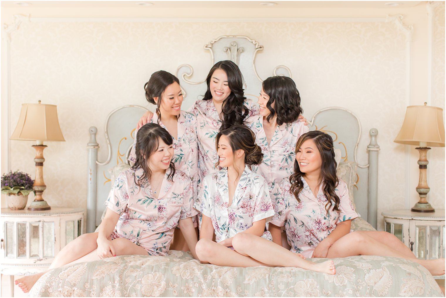 bride and bridesmaids sit on bed in Ashford Estate bridal suite