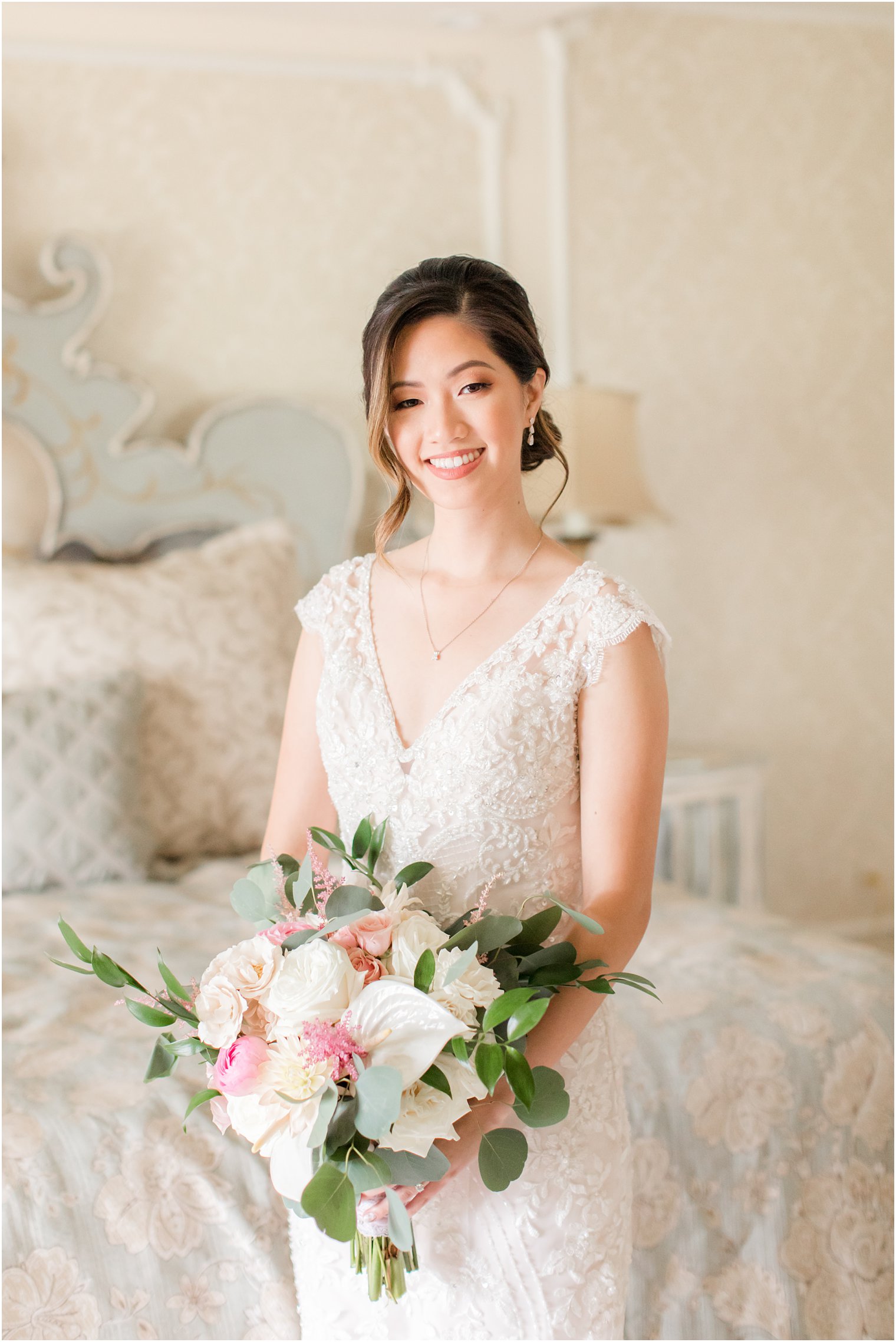 bride holds bouquet of white and pink flowers in bridal suite at Ashford Estate