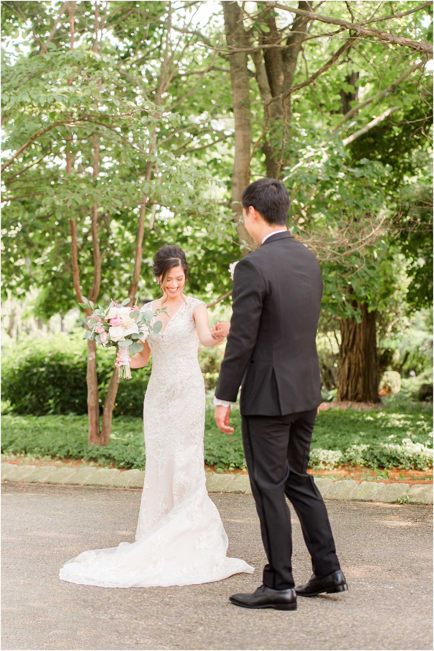 bride shows off wedding gown during first look with groom