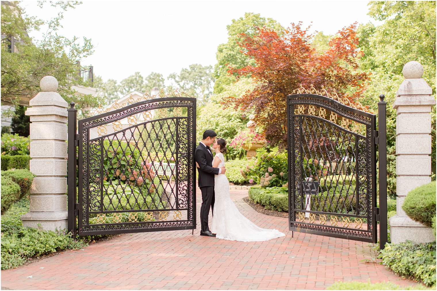 newlyweds pose by wrought iron gates at Ashford Estate