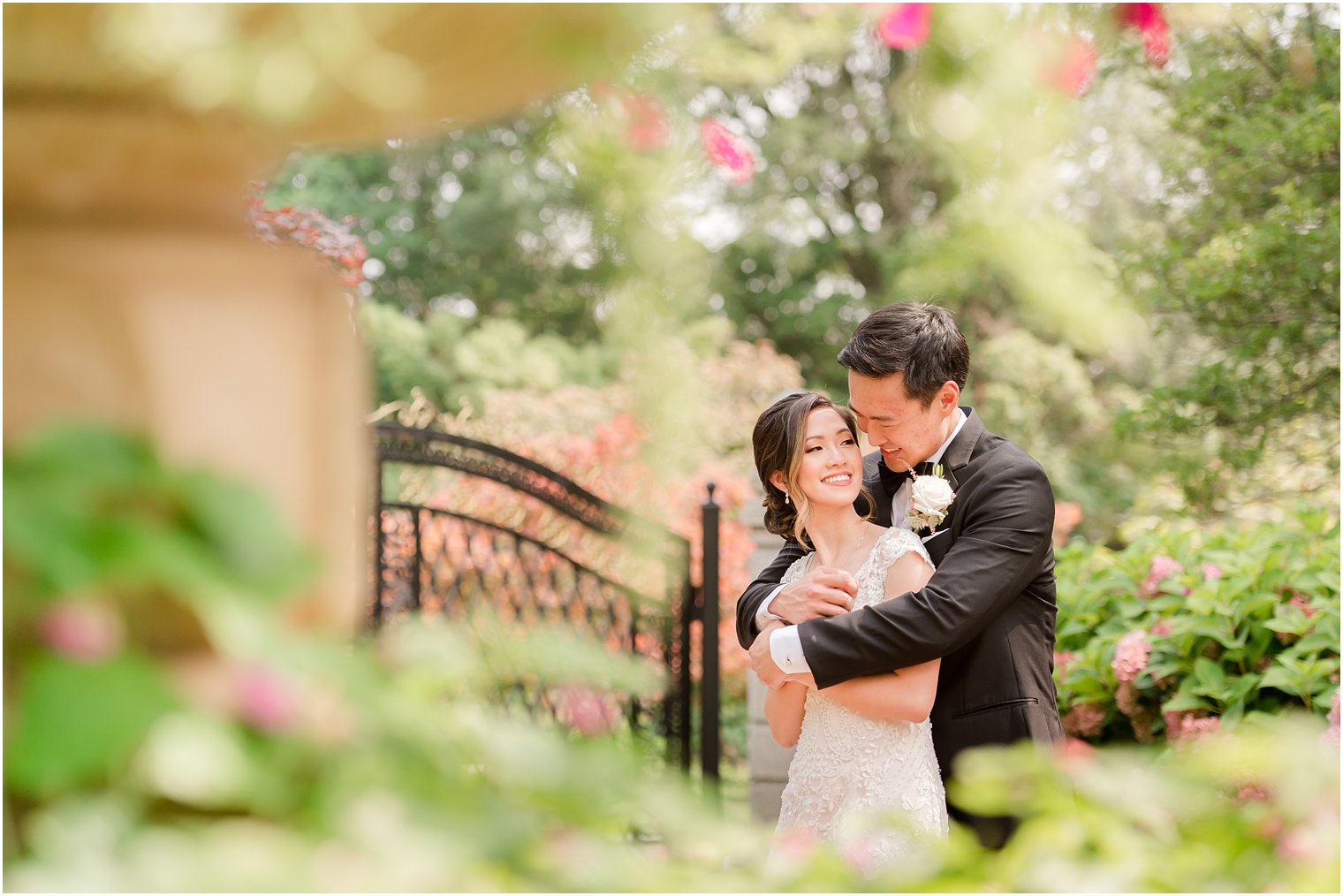 groom hugs bride in gardens during summer Ashford Estate wedding 